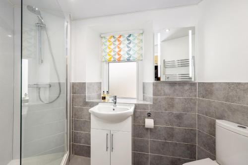 White bathroom with walk-in shower and patterned shower curtain