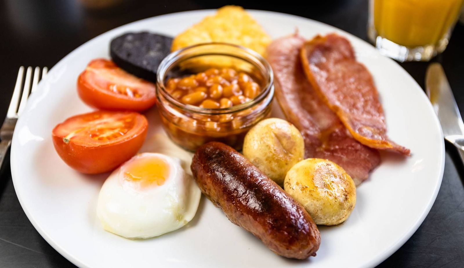 Full Cumbrian breakfast: sausage, bacon, black pudding, fried egg, tomato, mushrooms, beans and orange juice