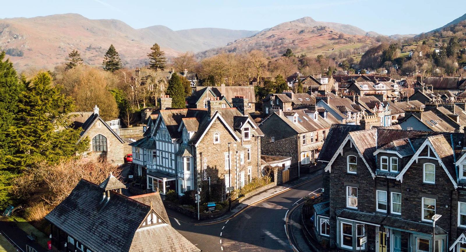 Aerial view of The Gables Guest House, the Victorian stone building with its upright THE GABLES sign, next to Zeffirellis cinema with the fells behind