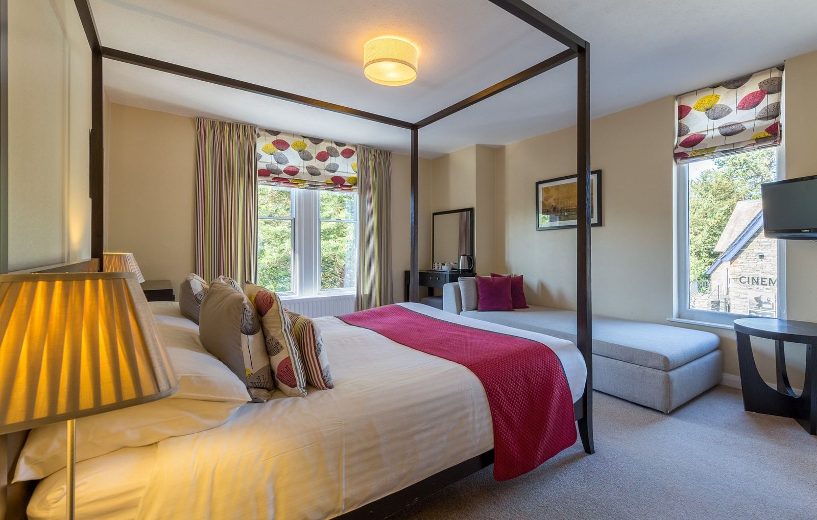Guest photograph of a four-poster bedroom with the cinema building visible through the window